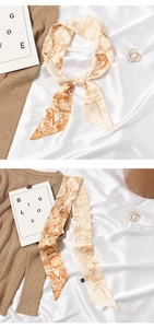 Detail of elegant skinny silk scarf with retro giraffe and bird prints on satin fabric