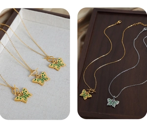 Détail de pendentifs papillon en or et argent avec des touches d'émail vert élégantes