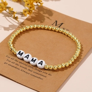 Golden beaded MAMA bracelet on a gift card with dried flowers for Mother's Day