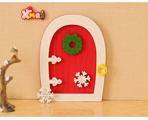 Miniature wooden Christmas door model with festive green wreath and white snowflakes