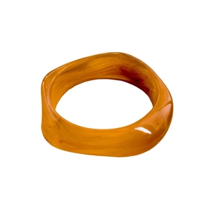Retro geometric amber resin bangle with irregular cut surface on a white background