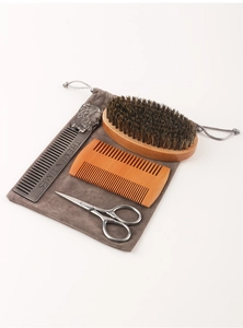Men's grooming kit featuring boar bristle brush, metal comb, and scissors on a gray pouch