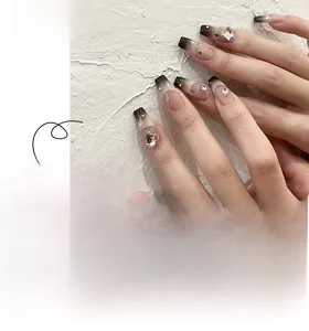 Detailed view of long ballerina nails with pink-to-black gradient, rhinestones, and star art