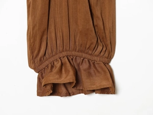 Detail of brown ruffle cuff with elastic smocked sleeve on casual fashion top