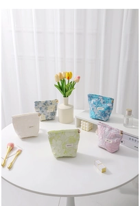 Detail of five floral jacquard cosmetic bags with embossed texture and metal zippers