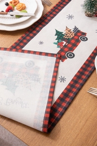 Detail of red truck and Christmas tree design on a red and black plaid table runner