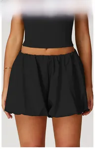 Detail view of high-waisted black yoga shorts with loose-fit bubble hem and elastic waist
