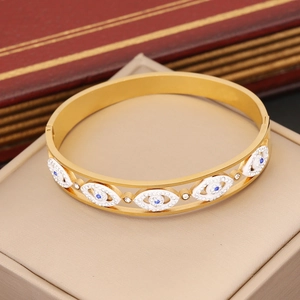 Detailed macro of gold-plated hollow evil eye bracelet with blue and white crystals