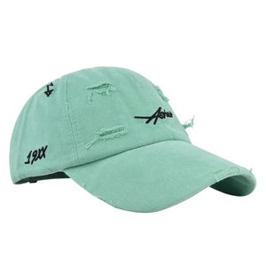 Close-up of mint green distressed baseball cap with 19XX Aster embroidery detail