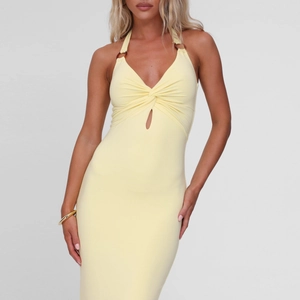 Detail of light yellow bodycon dress showing deep V-neck, twist design, and cut-out detail