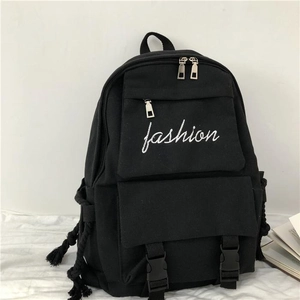 Detail of black canvas backpack showing spacious main compartment and fashion embroidery