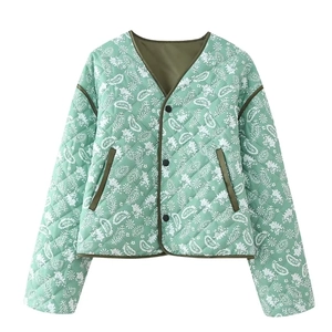 Detail of mint green quilted jacket featuring white paisley patterns and diamond stitching