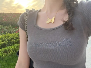 Close-up of golden butterfly necklace with hollow engraving on neck for women