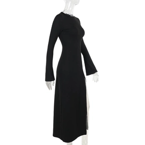 Detail view of the high side slit on a black slim fit long sleeve maxi dress