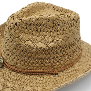 Détail du chapeau de cowboy en paille avec bande en corde et boucles métalliques vintage
