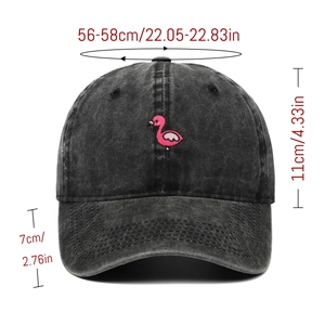 Detailed view of pink flamingo embroidery on washed black cotton baseball cap with sizing info