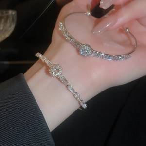 Elegant silver open bangle featuring sparkling round and baguette-cut cubic zirconia
