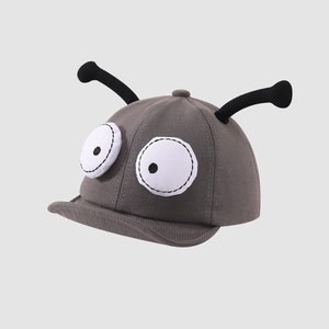 Close-up of baby sun hat featuring funny large cartoon eyes and 3D insect antennas