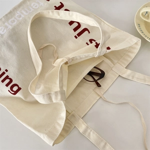 Détail du grand sac cabas en toile beige avec imprimé rouge montrant sa grande capacité