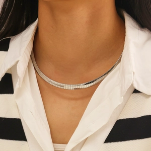 Close-up of flat silver snake chain choker necklace with polished metallic finish