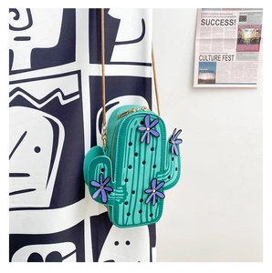 Detail of green cactus crossbody bag with purple flowers and golden chain strap