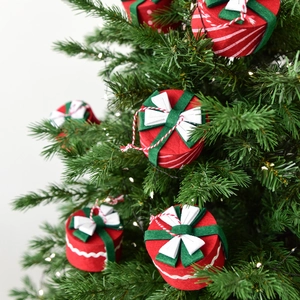 Mini round Christmas gift box hanging ornament with red felt and white bow on a tree