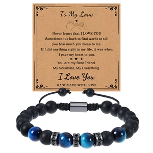 Gros plan sur bracelet en perles œil de tigre noir mat et bleu avec carte de message