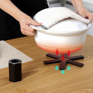 Star-shaped wooden heat insulation pad protecting table from a white ceramic pot