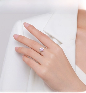 Detailed view of teardrop opal ring on finger featuring sparkling zircon stones around it