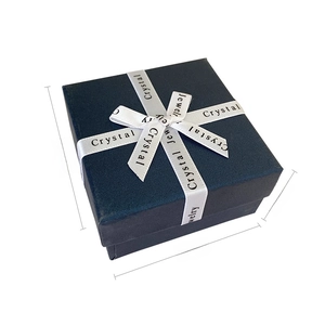 Navy blue jewelry gift box with textured finish and decorative white silk ribbon bow