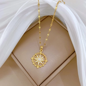 Detailed view of a gold starburst pendant with white zircon crystals on a jewelry box