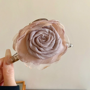 Detailaufnahme einer Haarspange mit rosa Organza-Rose und mehrlagigen Stoffblütenblättern