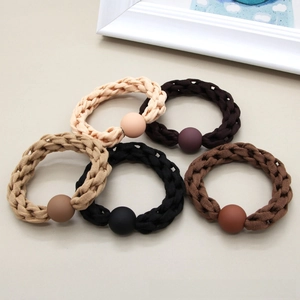 Detail view of five milk tea colored woven hair ties with matching matte beads