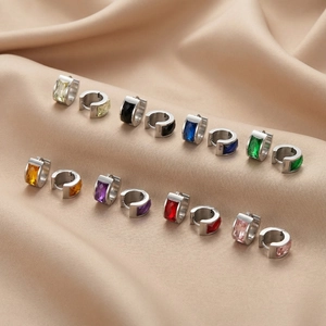 Detailed macro view of colorful rectangular zircon inlay on polished steel earrings