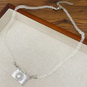 Macro-opname van camerahanger met parellens en kristallen kralen op een punk-stijl ketting