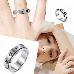Detail of silver titanium spinning ring featuring engraved cross and turtle patterns