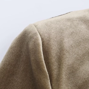 Detail shot of khaki velvet dress showing pleated shoulder seams and soft fabric texture