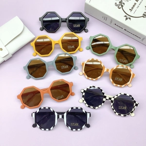 Flat lay of colorful geometric PC kids sunglasses with UV400 protection and a white pouch