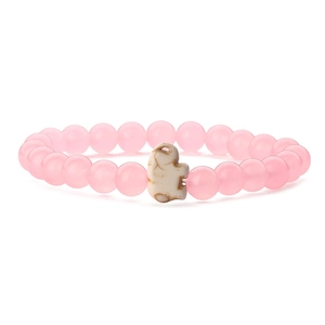 Close-up of pink crystal bead bracelet featuring a cute white elephant charm accent