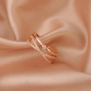 Detailed macro of rose gold double-layer criss-cross ring with sparkling zircon stones