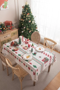 Close-up of Christmas tablecloth with fringe, featuring red and green holiday patterns
