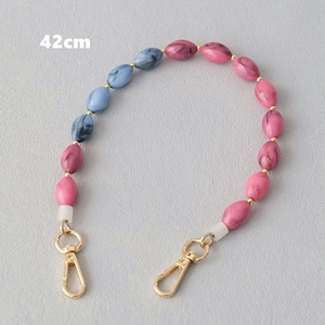 Détail de la chaîne de 42cm en perles acryliques rose et bleu avec crochets dorés