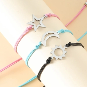 Three-piece sun moon and star handmade woven cord bracelets on a white display stand