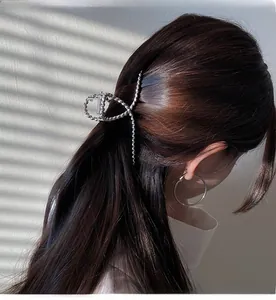 Detail of silver twisted metal hair claw and large hoop earrings on a fashion model