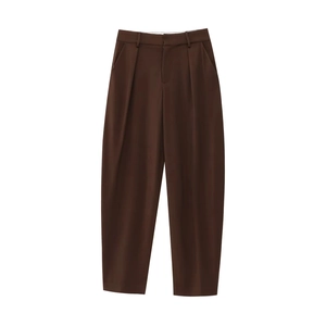 Detail of chocolate brown suit trousers featuring front pleats and side pockets
