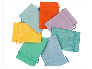 Close-up of colorful linen drawstring pouches arranged in a circle for jewelry packaging