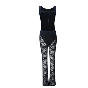 Detail of black lace jumpsuit showing intricate mesh texture and lace-up neck details
