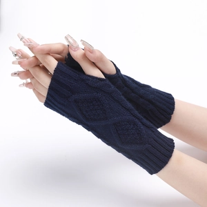Macro detail of navy blue diamond cable knit texture on winter fingerless arm warmers