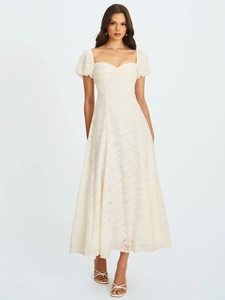 Détail du tissu jacquard blanc élégant et des manches bouffantes de la robe longue