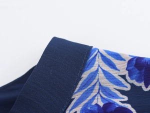 Close-up of elegant dark blue collar and floral print chiffon fabric on dress detail